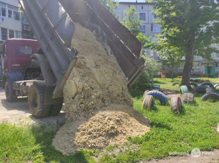 На детские площадки Покровска завозят песок